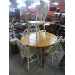 A circular pine extending dining table and four beech chairs