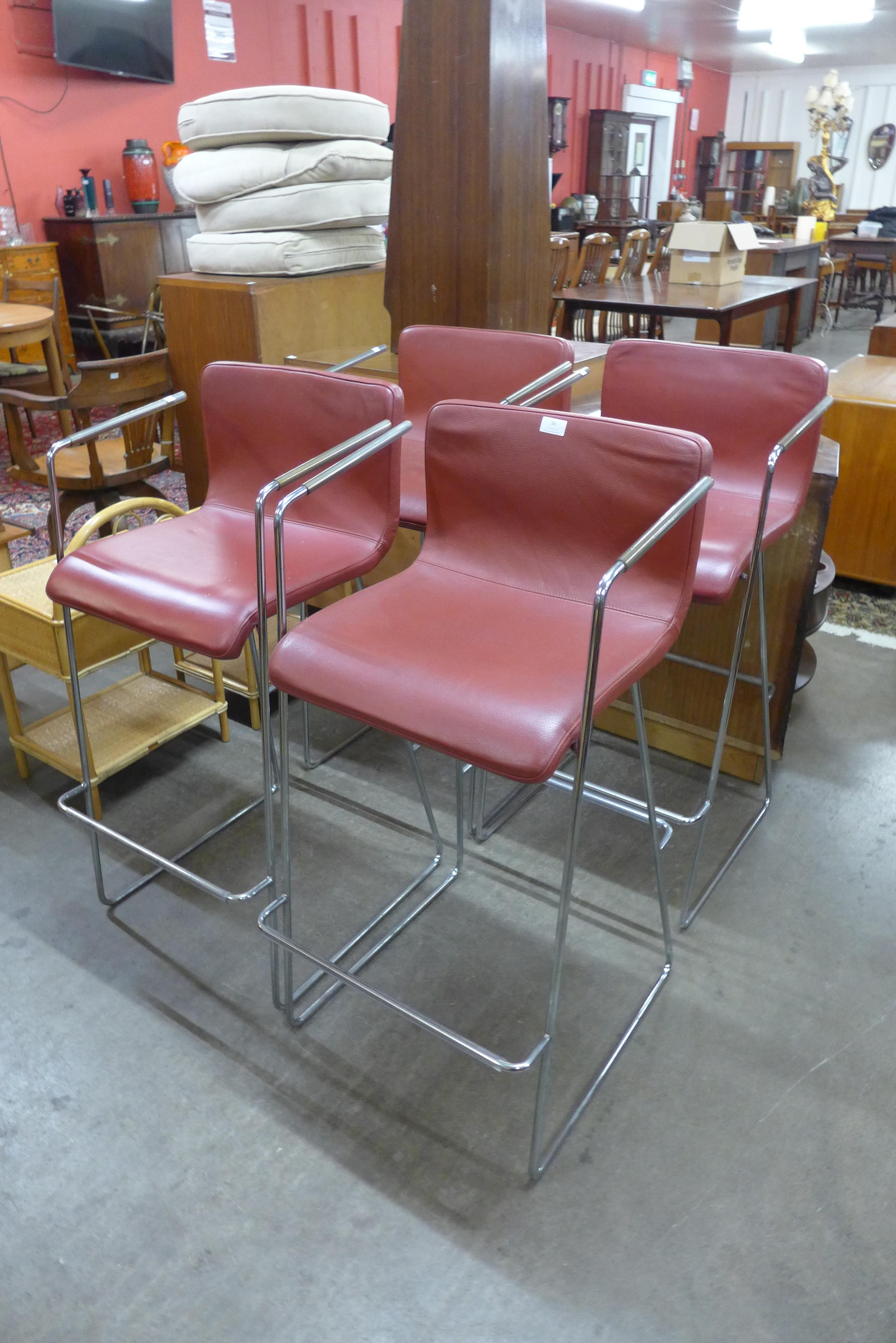 A set of four chrome and red vinyl bar stools