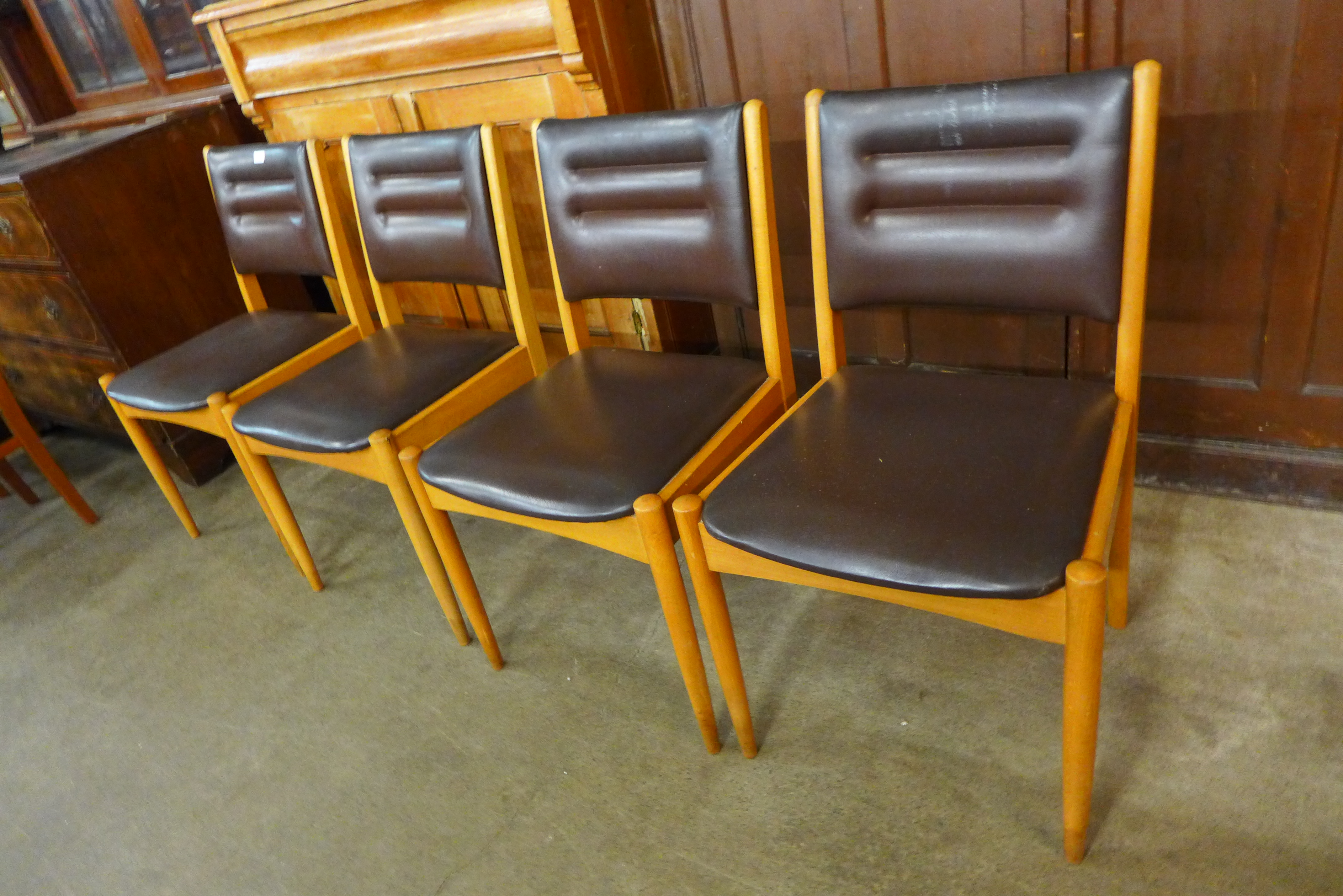 A set of four beech and brown vinyl dining chairs