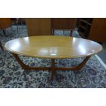 An oval teak coffee table