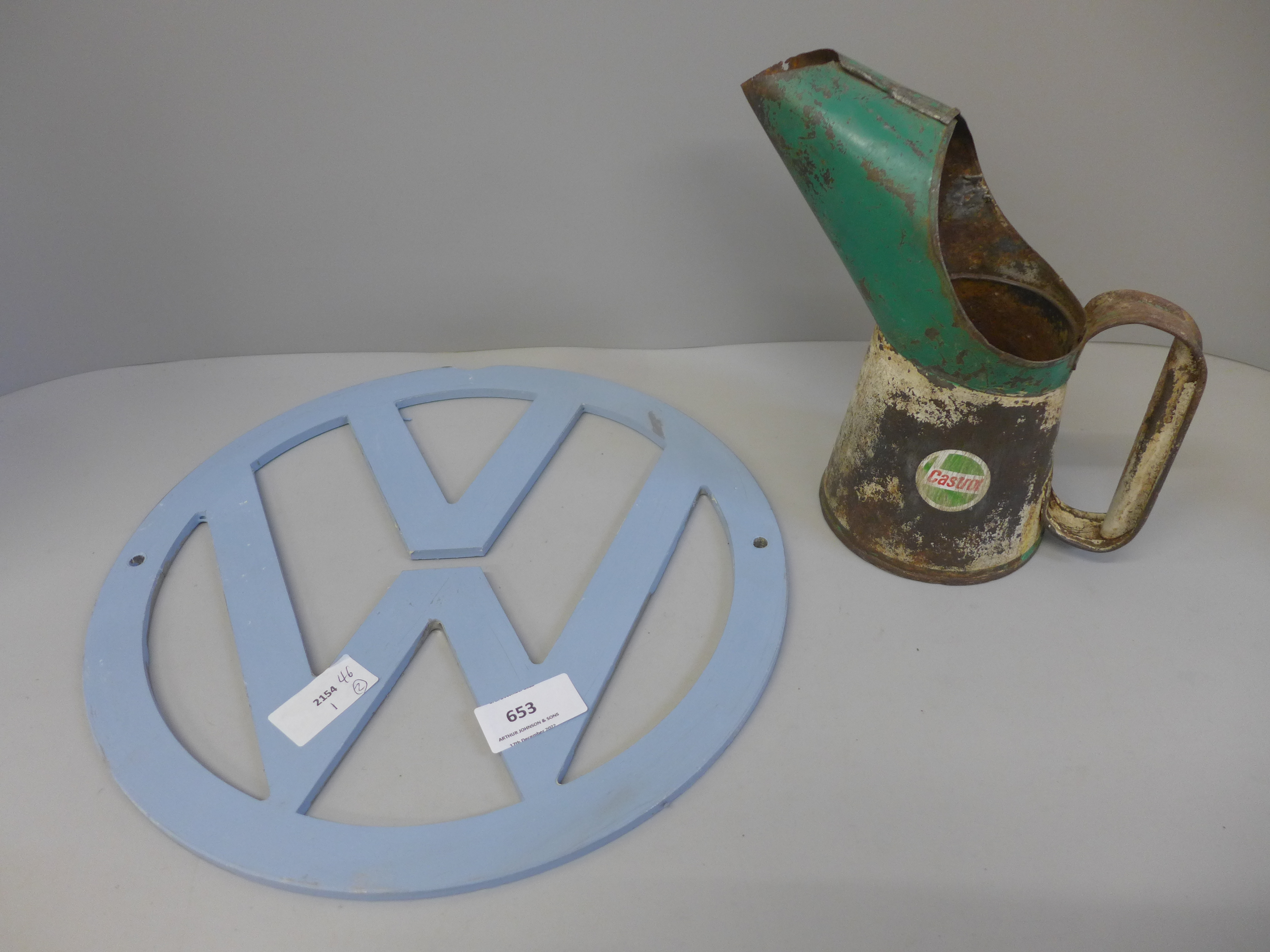A metal VW sign and a Castrol oil can