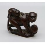 A carved rosewood netsuke of two monkeys, signed on the base