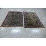 A pair of hand knotted Pakistani green ground Bokhara rugs