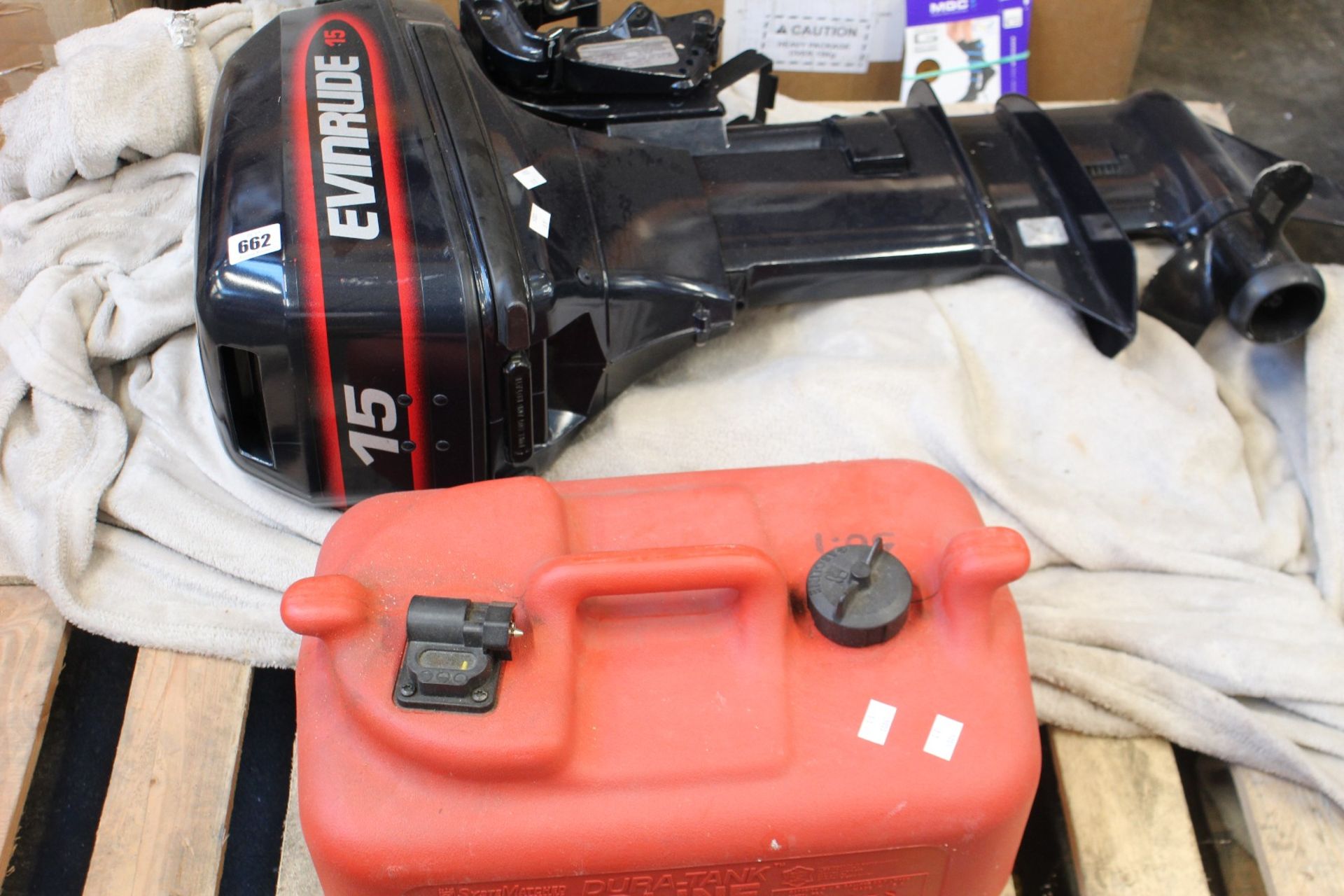 A pre-owned Evinrude 15 1998 unleaded fuel outboard motor and a pre-owned Dura-Tank container (