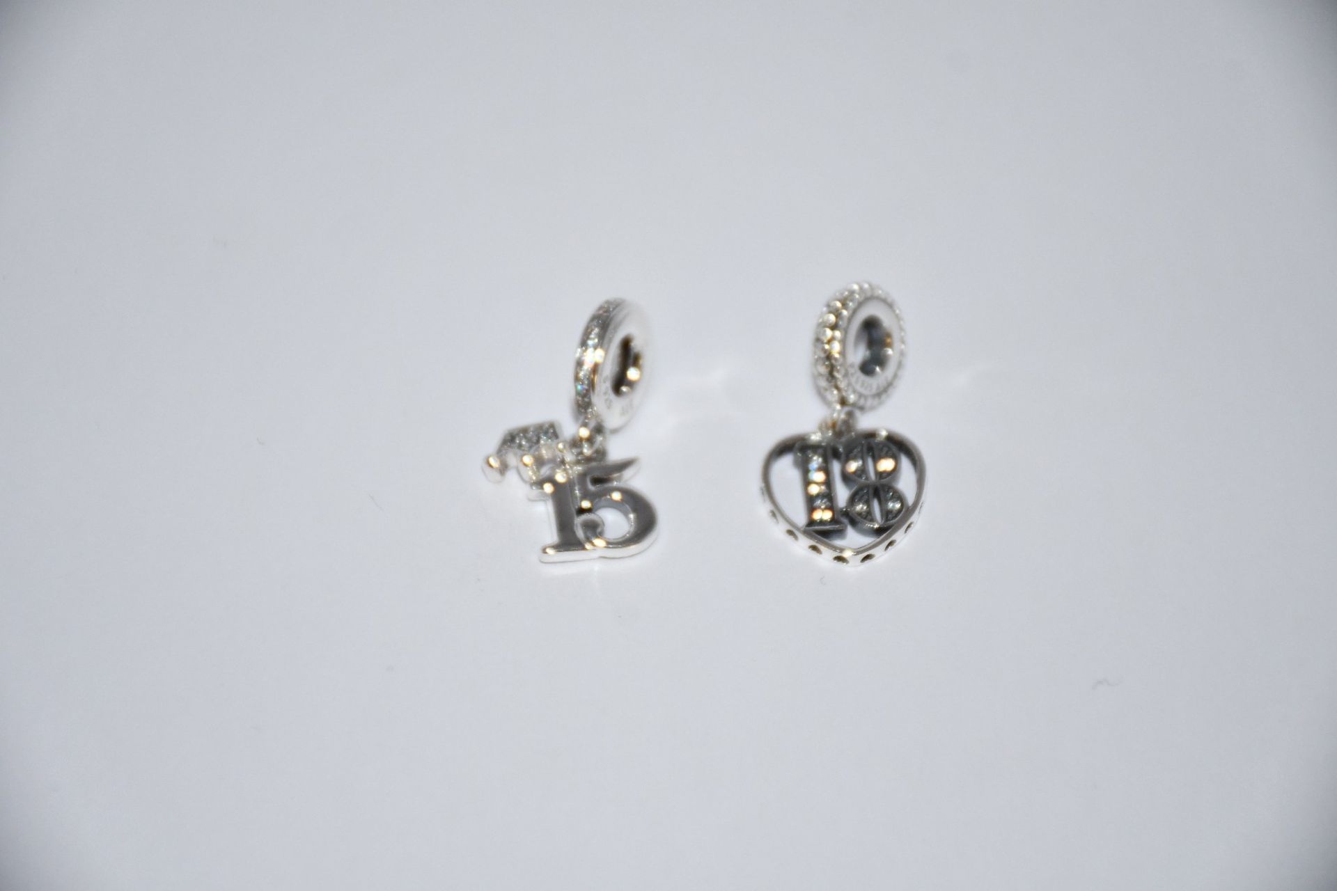 A Pandora 18th Celebration Dangle charm (RRP £40) and two Pandora 15th Birthday Dangle charms (