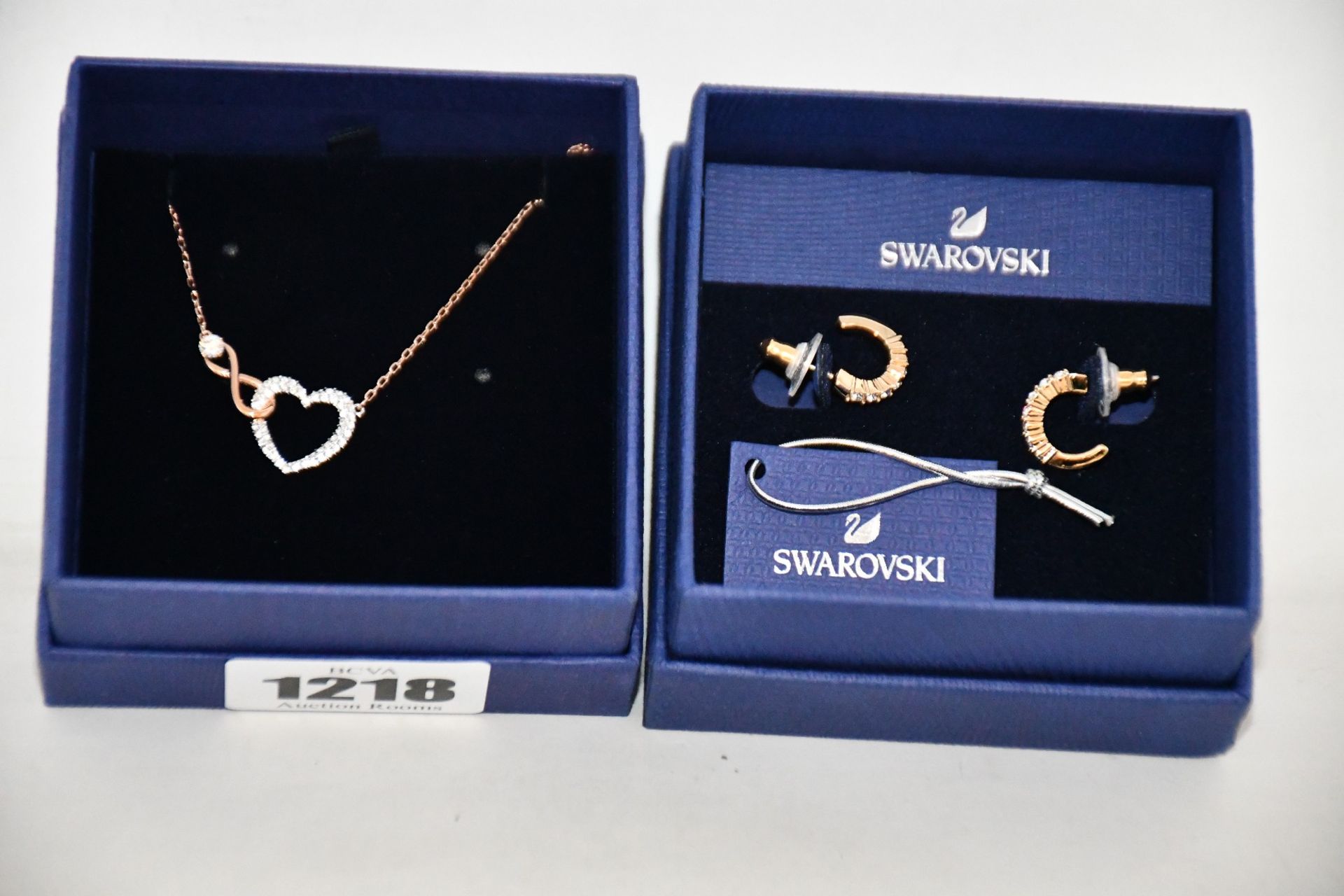 An as new Swarovski Infinity Heart necklace and a pair of hoop earrings.