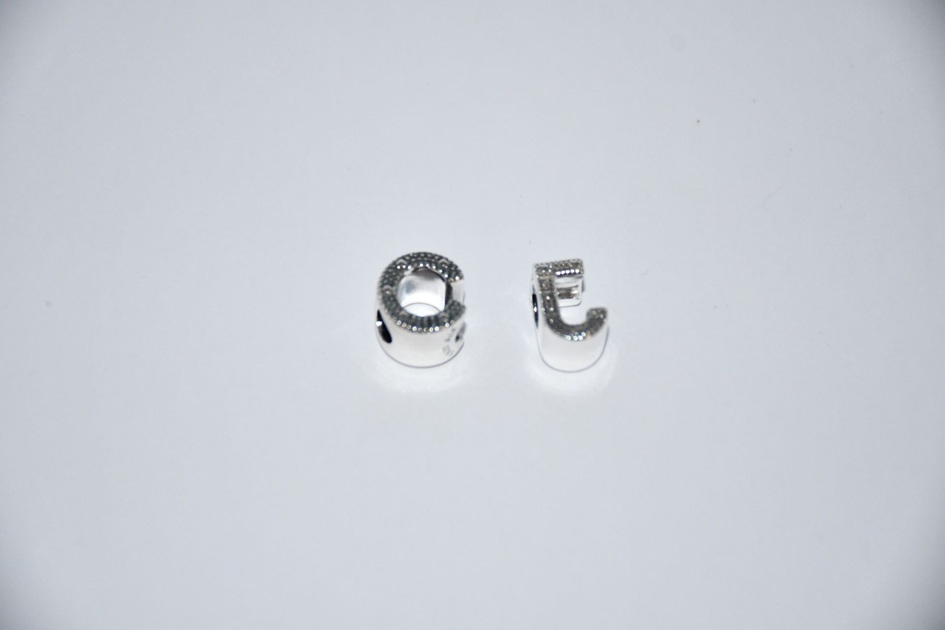 Three Pandora Letter C Alphabet charms (RRP £25) and a Pandora Letter J Alphabet charm (RRP £25).