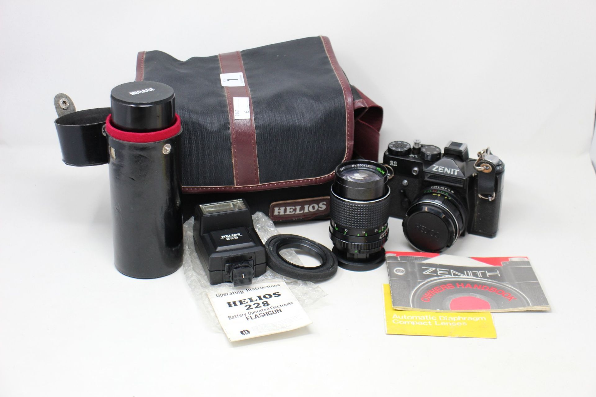 A pre-owned Zenit 11 35mm film camera with a flash gun and three lenses to include Mirage and two