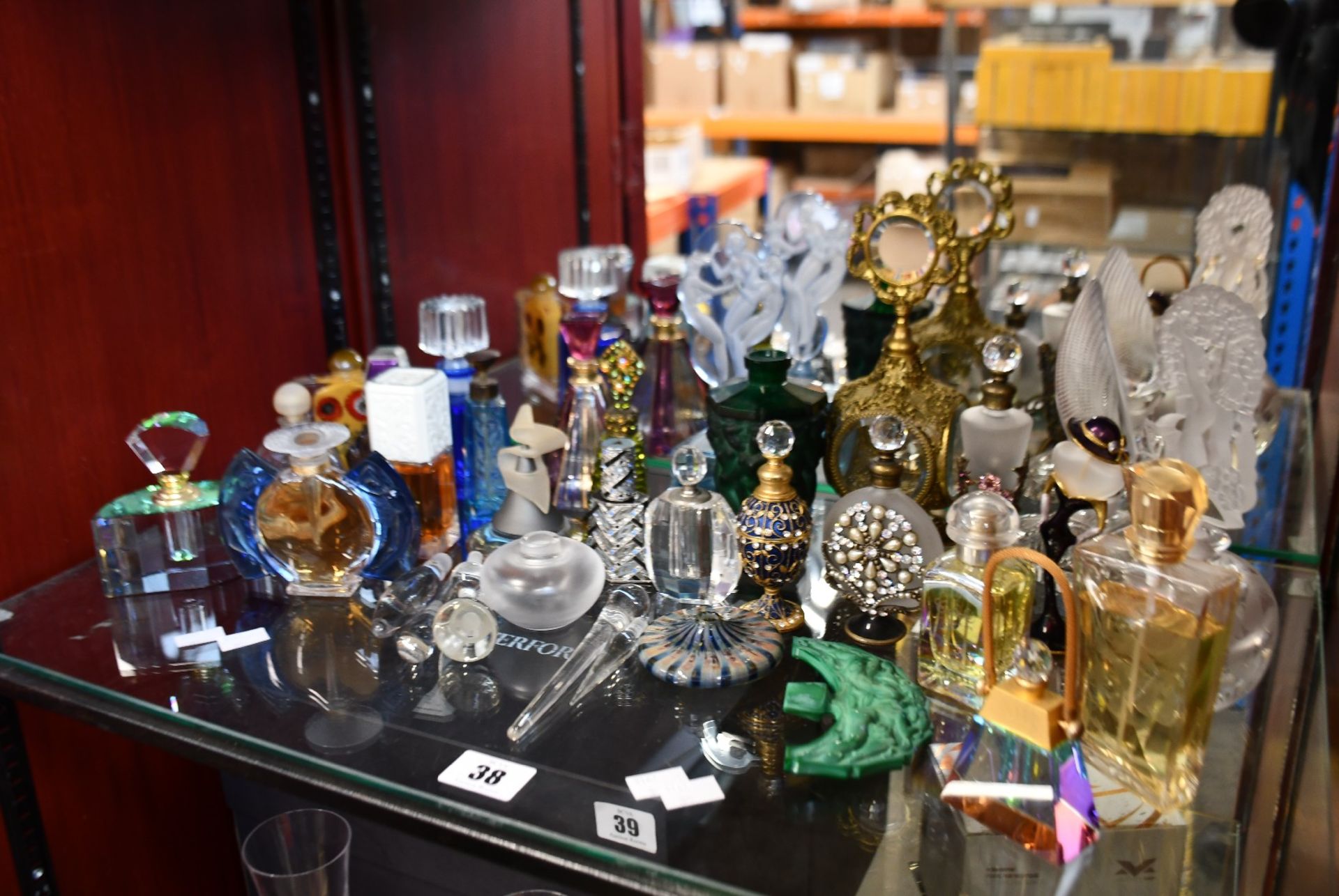 A variety of mostly empty/factice perfume bottles and glass stoppers.