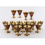 A matched set of 17 English enamelled brass goblets, some with Chinese style bird decoration