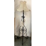 A wrought iron standard lamp, with shade