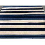 A large modern blue and white striped rug, 304x230cm