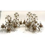 A lot of four gilt metal three arm acanthus wall sconces, with cut glass drops, each 38cmH