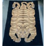 A cross stitch 'tiger skin' rug 183x123cm