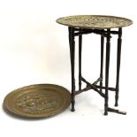 A folding table with two embossed brass chargers