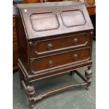 A 20th century oak bureau, with geometric mouldings, on cup and cover supports, 75x42x100cmH