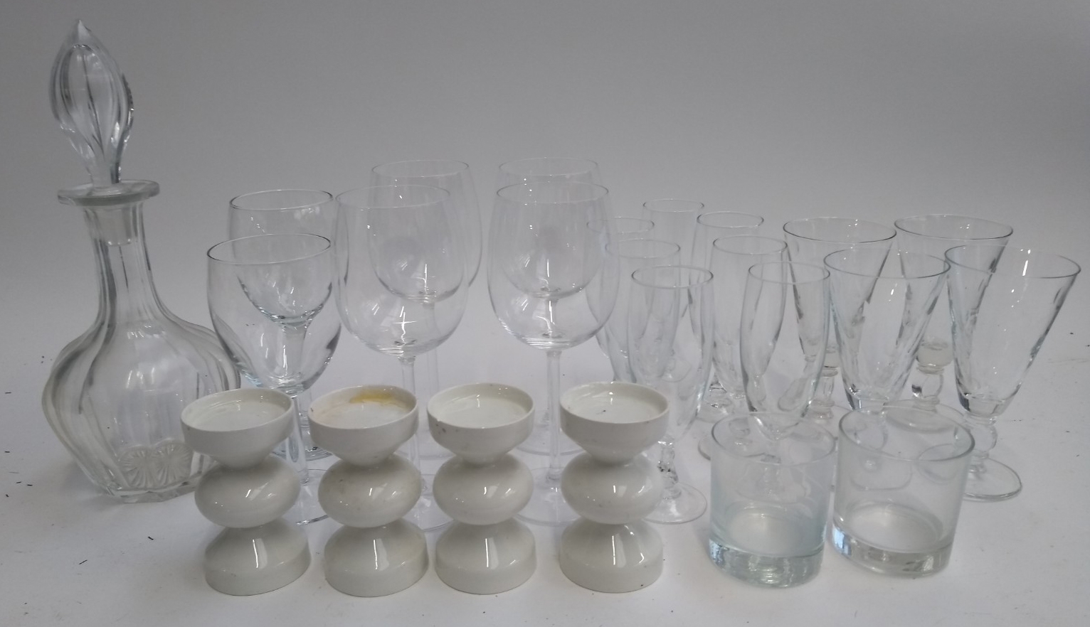 A quantity of glasses to include tumblers and wine glasses; together with four tea light holders