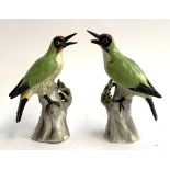 A pair of ceramic green woodpeckers, 23cmH, one with damage lower bill