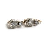 A pair of 14ct gold and two stone diamond earrings with platinum fronts, the larger diamonds in a
