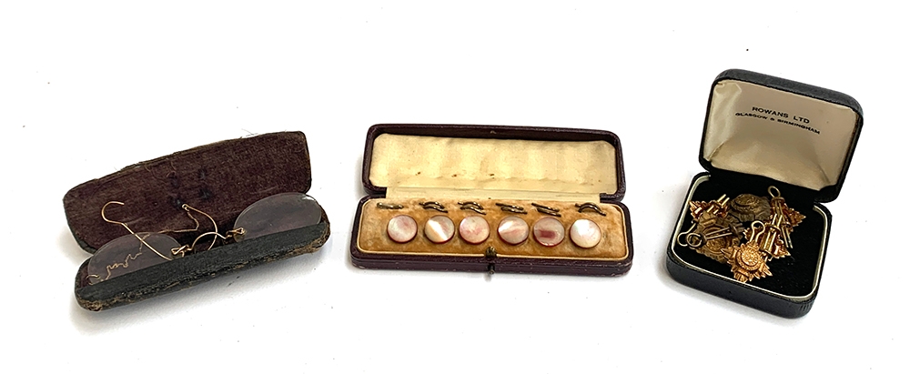 A cased set of 6 mother of pearl studs, yellow metal mounted pince nez glasses, various military cap