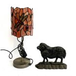 A cast iron doorstop in the form of a ram; together with a modern table lamp with Tiffany style