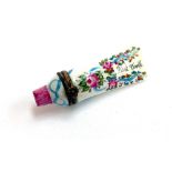 A Limoges 'First Tooth' trinket pot in the form of a toothpaste tube, with hand painted floral
