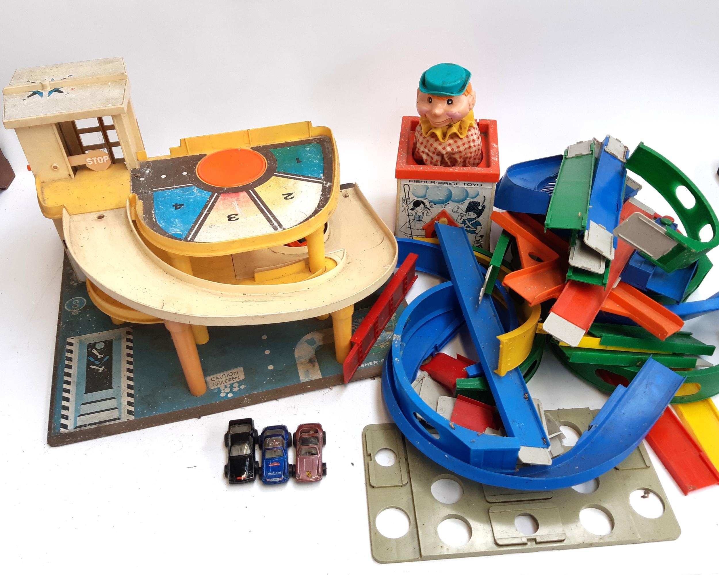 A Fisher Price car garage, together with a jack in the box and a quantity of loop the loop track and