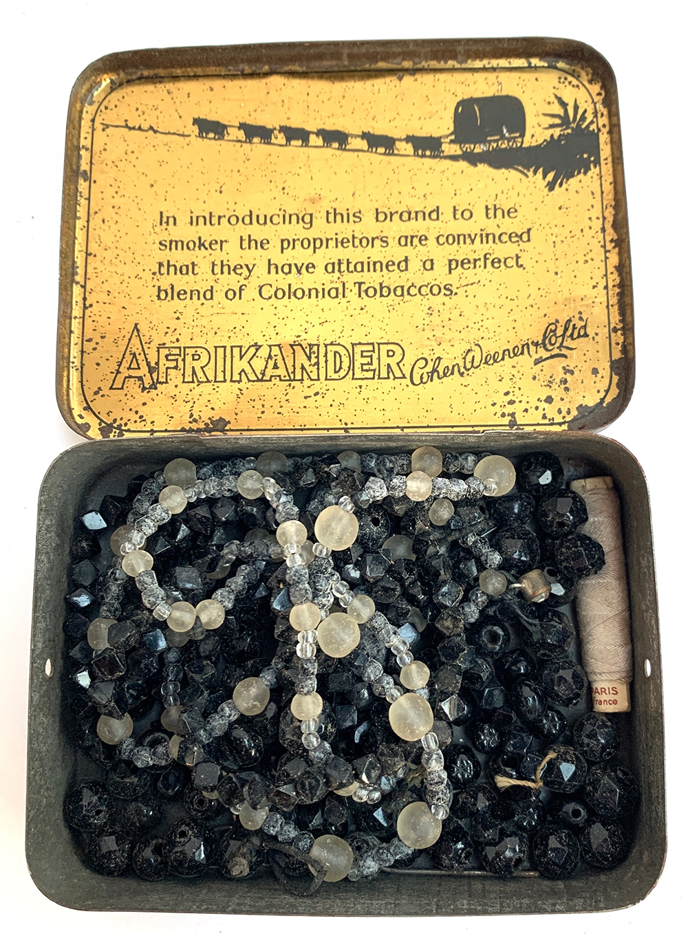 A tin containing a quantity of French jet and other beads