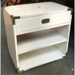 A modern campaign style white painted cabinet, with metal corners, single drawer over two shelves,