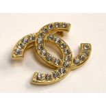 A Chanel style gilt metal and white stone CC logo brooch, marked 'Paris' to reverse, 5cmW