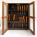 A glazed cabinet containing a quantity of chisels, mostly Marples, the cabinet 56x64cm