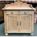 A Victorian pine wash stand, three quarter gallery over two drawers and two cupboard doors, bun