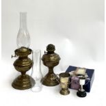 Two brass oil lamps, one with glass chimney, together with an unassociated glass chimney and several