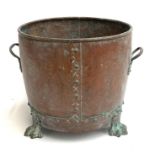 A riveted copper and brass coal bucket with twin carry handles on three paw feet, 34cmD, 31cmH