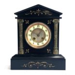 A slate mantel clock, pediment top, dial flanked by applied metal columns, on plinth base, with