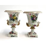 A pair of hand painted Continental urns, with twin gilt green man handles, allover painted with