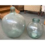 A very large blown glass demijohn/carboy, 57cmH; together with one other smaller, 35cmH
