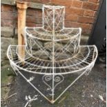 A three tier white painted wrought metal semi circular plant stand; together with three other