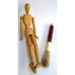 An artist's wood mannequin, 52cmH, together with a large brush with hard stone handle, 37cmL