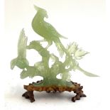 A Chinese carved jade figure group of birds on a branch on a carved hardwood base, 26.5cmH