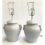 A pair of large table lamps in the form of twin handled urns (one handle damaged), height to top