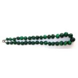 An early 20th century hand carved malachite graduated bead necklace, sterling silver clasp, 57cmL