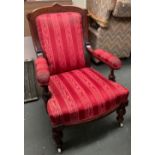A mahogany framed open armchair, with stuffover serpentine seat, on carved legs and ceramic casters,