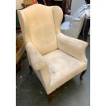 A late 19th/early 20th century wingback armchair, with outward scrolling arms and cabriole legs,