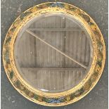 A parcel painted and gilt framed circular mirror, carved with fruits and foliage, 52cmD