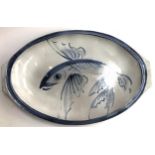 A large glazed terracotta serving dish, depicting a flying fish, 57cmL