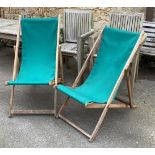 A pair of folding deck chairs, in a green fabric