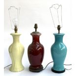 Three ceramic table lamps, the tallest 49cmH to the top of fitting, together with two shades