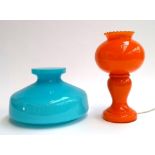 A mid century orange glass table lamp, 28cmH, together with a blue glass lamp shade, 25.5cmD