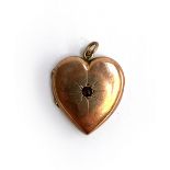 A 9ct gold back and front locket in the form of a heart, set with a red stone, approx. 3.9g